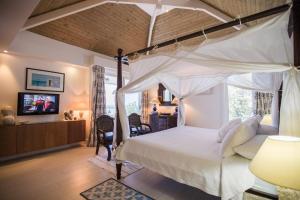 a bedroom with a canopy bed and a tv at Dream Villa Orient Bay 570 in Orient Bay