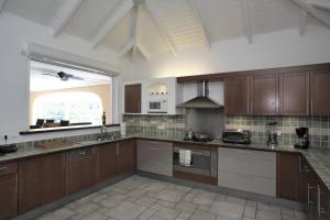 a large kitchen with wooden cabinets and a large window at Dream Villa Terres Basses 543 in Les Terres Basses