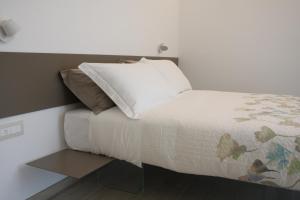 a bed with a white blanket and pillows on it at ARIA Design B&B Levanto in Levanto