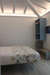 a white room with a bed and a tv at ARIA Design B&B Levanto in Levanto