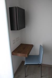 a table with a chair and a television on a wall at ARIA Design B&B Levanto in Levanto