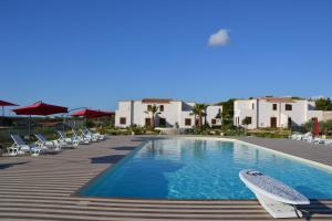 una piscina con tumbonas y un complejo en Case Vacanza Torre Lupa en Marsala