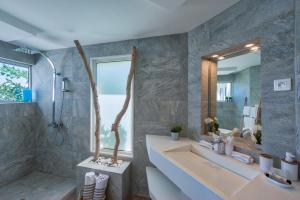Dream Villa Orient Bay 566 في أويينت باي: حمام مع حوض ومغسلة ومرآة