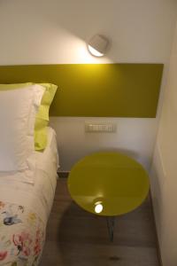 a green table next to a bed in a room at ARIA Design B&B Levanto in Levanto