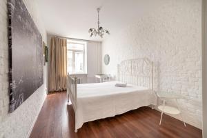 Dormitorio blanco con cama y pared de ladrillo blanco en SutkiMinsk Economy, en Minsk