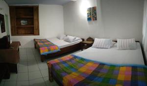 una camera con due letti e una tv di Bromo Tanjung a Tosari
