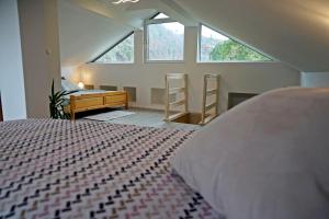 Schlafzimmer mit einem Bett, einem Schreibtisch und Fenstern in der Unterkunft Apartma Eržen in Zgornje Gorje