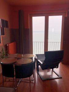 a dining room with a table and chairs and windows at Club 218 Panoráma Apartman in Siófok