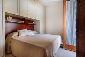 sypialnia z łóżkiem z drewnianym zagłówkiem w obiekcie Il Tulipano - Appartamento al centro di Vico Equense w mieście Vico Equense