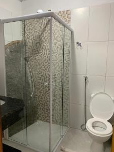 a bathroom with a glass shower with a toilet at Flats Alto das Pedras in Trindade +41 photos