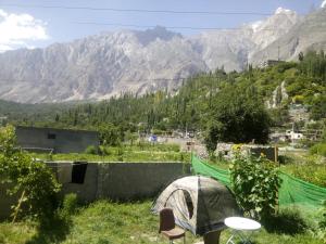 a tent in a field with mountains in the background at Four Seasons Guest House Hunza in Hunza