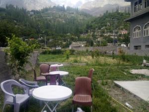 a group of tables and chairs with a view of a mountain at Four Seasons Guest House Hunza in Hunza