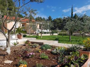 a garden with flowers and plants in front of a house at Secluded Seaside Holiday Home in Milna