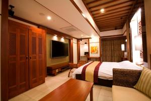 ein Hotelzimmer mit einem Bett und einem TV in der Unterkunft Hotel Bintang Pari Resort (Adult Only) in Kōbe