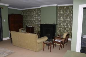 a living room with a couch and a fireplace at Lastingham Country Lodge in Lidgetton