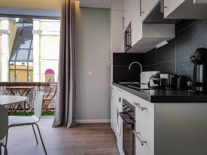 a kitchen with white counters and a table and a window at Julio Apartment in Faro - Down Town Center in Faro