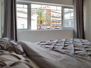 a bedroom with a bed and a large window at Julio Apartment in Faro - Down Town Center in Faro