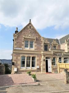 un antiguo edificio de ladrillo con una puerta blanca en No 48 Castle View, en Inverness