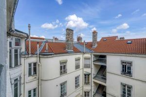 un groupe de bâtiments avec des cheminées sur les toits dans l'établissement HONORÊ - Suite Carnot, à Lyon 4 autres photos