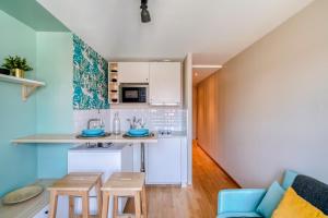 a kitchen and living room with a couch and a table at HONORÊ - Suite Carnot in Lyon