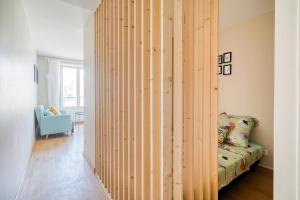 - une cloison en bois dans une chambre avec un canapé dans l'établissement HONORÊ - Suite Carnot, à Lyon