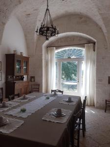 a dining room with a table and a large window at Masseria Gianca in Cisternino