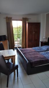 een slaapkamer met een bed, een tafel en een stoel bij Gästezimmer Hille in Bad Schandau