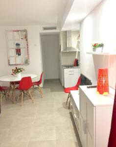cocina con mesa y sillas rojas en una habitación en Corralejo Sun 202, en Corralejo