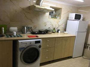 a kitchen with a washing machine and a refrigerator at Hotel Rafinad in Lviv