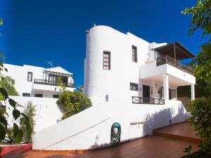 a white building with a black car parked in front of it at 2BR Beach House - Solarium & Shower Terrace - 12 in Puerto del Carmen