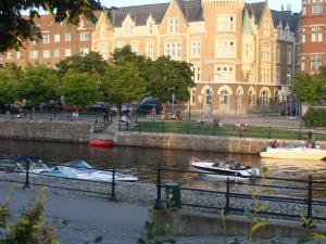 two boats in a river in front of a large building at Hotell Alderholmen in Gävle