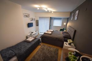 a small room with two beds and a couch at Urban Apartment in Niš