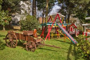 een speeltuin met een speelgoedpaard in een houten wagen bij Jardim Nevada in Campos do Jordão
