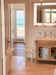 een badkamer met een wastafel en een spiegel bij Strandhuus - Urlaub aan de Ostsee in Timmendorfer Strand