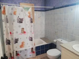 a bathroom with a shower curtain with cats on it at Cala Galdana Beach in Cala Galdana +29 photos