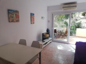 sala de estar con mesa de comedor y TV en Cala Galdana Beach, en Cala Galdana