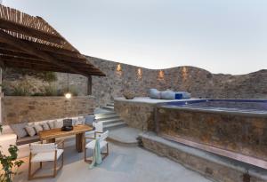 a patio with a bed and a swimming pool at Mykonos Panormos Villas in Mykonos