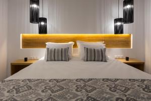 a bedroom with a large bed with two pillows at Mykonos Panormos Villas in Mykonos