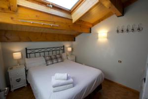 um quarto com uma cama grande e toalhas em Apartamento Els Vinyals em Estavar