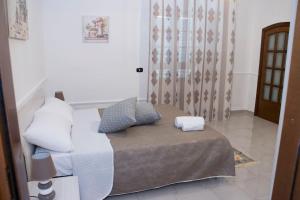 Cette chambre comprend un lit, un canapé et une fenêtre. dans l'établissement Tonia's mansion, à Bari