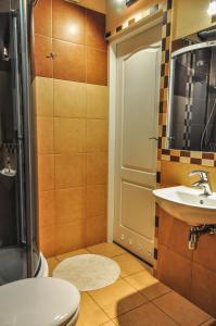 y baño con aseo, lavabo y ducha. en Apartamenty Numer 6, en Lublin