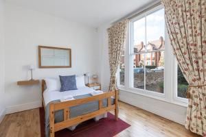 ロンドンにあるBright Clapham flat with private garden, sleeps 4のベッドルーム1室(ベッド1台、大きな窓付)