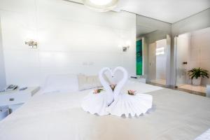 two swans shaped like hearts sitting on a bed at Marruá Hotel in Bonito