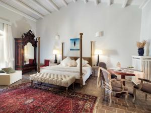 1 dormitorio con 1 cama, mesa y sillas en Gagliardi Boutique Hotel, en Noto