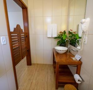 a bathroom with a sink and a bowl on a table at Marruá Hotel in Bonito