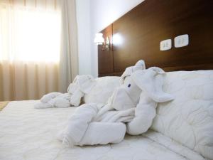two stuffed elephants are laying on a bed at Marruá Hotel in Bonito
