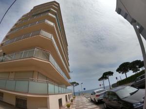 wysoki budynek z samochodami zaparkowanymi na parkingu w obiekcie Apartamento a primera linea de mar en platja d’aro w mieście Platja  d'Aro