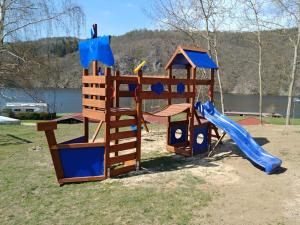 un parque infantil de madera con un tobogán y una honda en Juniorcamp Nová Živohošť, en Křečovice
