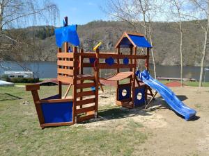 einen Holzspielplatz mit Rutsche und Rutsche in der Unterkunft Juniorcamp Nová Živohošť in Křečovice