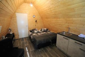 ein Schlafzimmer mit einem Bett in einem Holzzimmer in der Unterkunft Luxe Eco Pod op Camping de Stal in Drijber